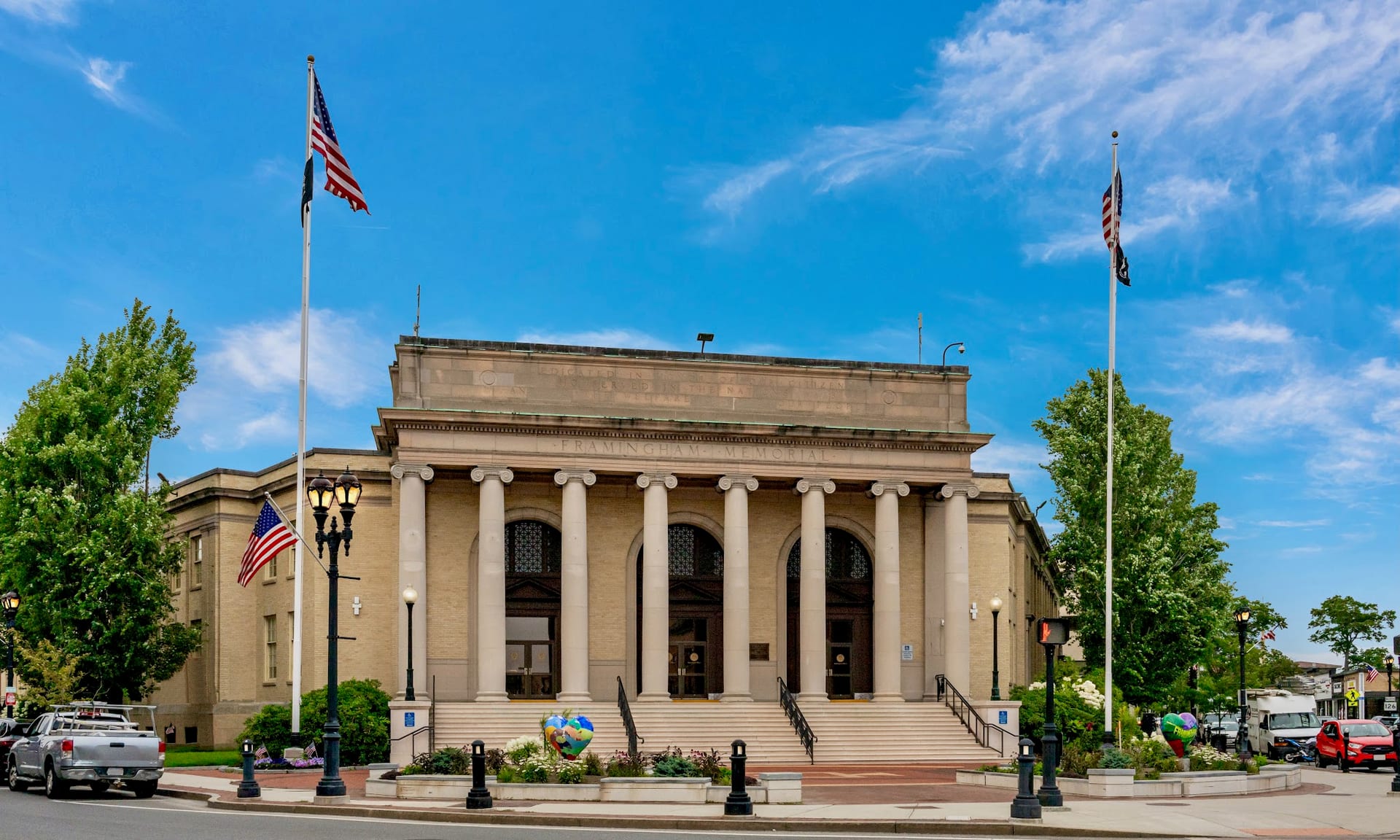 Framingham Memorial Building with columned facade and American flags on sunny day