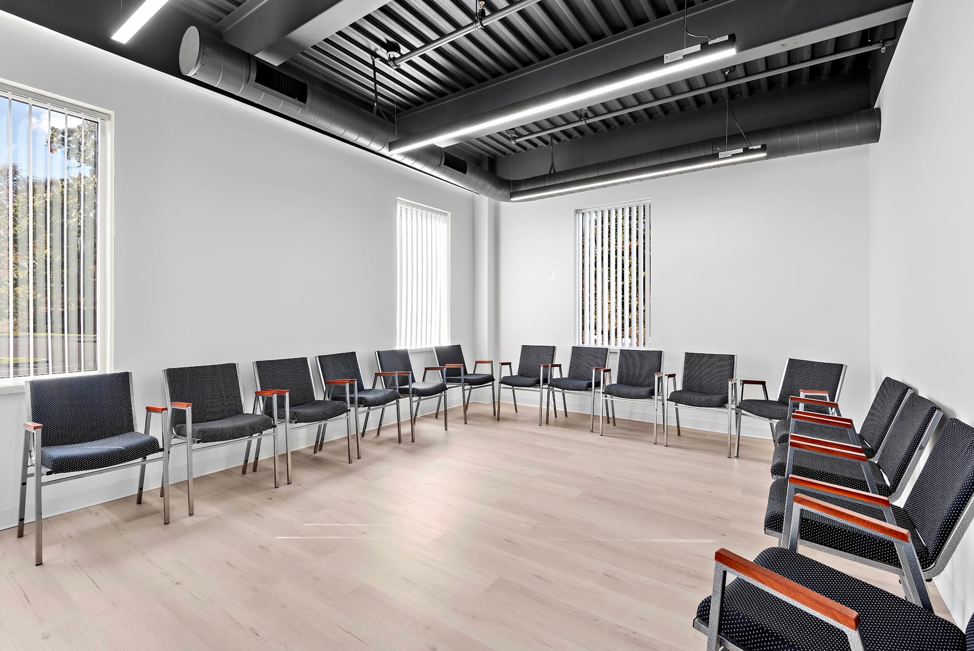 Circle of chairs arranged for group therapy in a bright treatment room