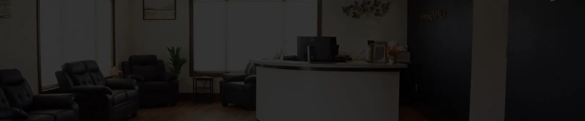 Welcoming reception desk and leather seating in a mental health clinic waiting area