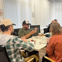 Small group of adults engaged in a therapy session around a table