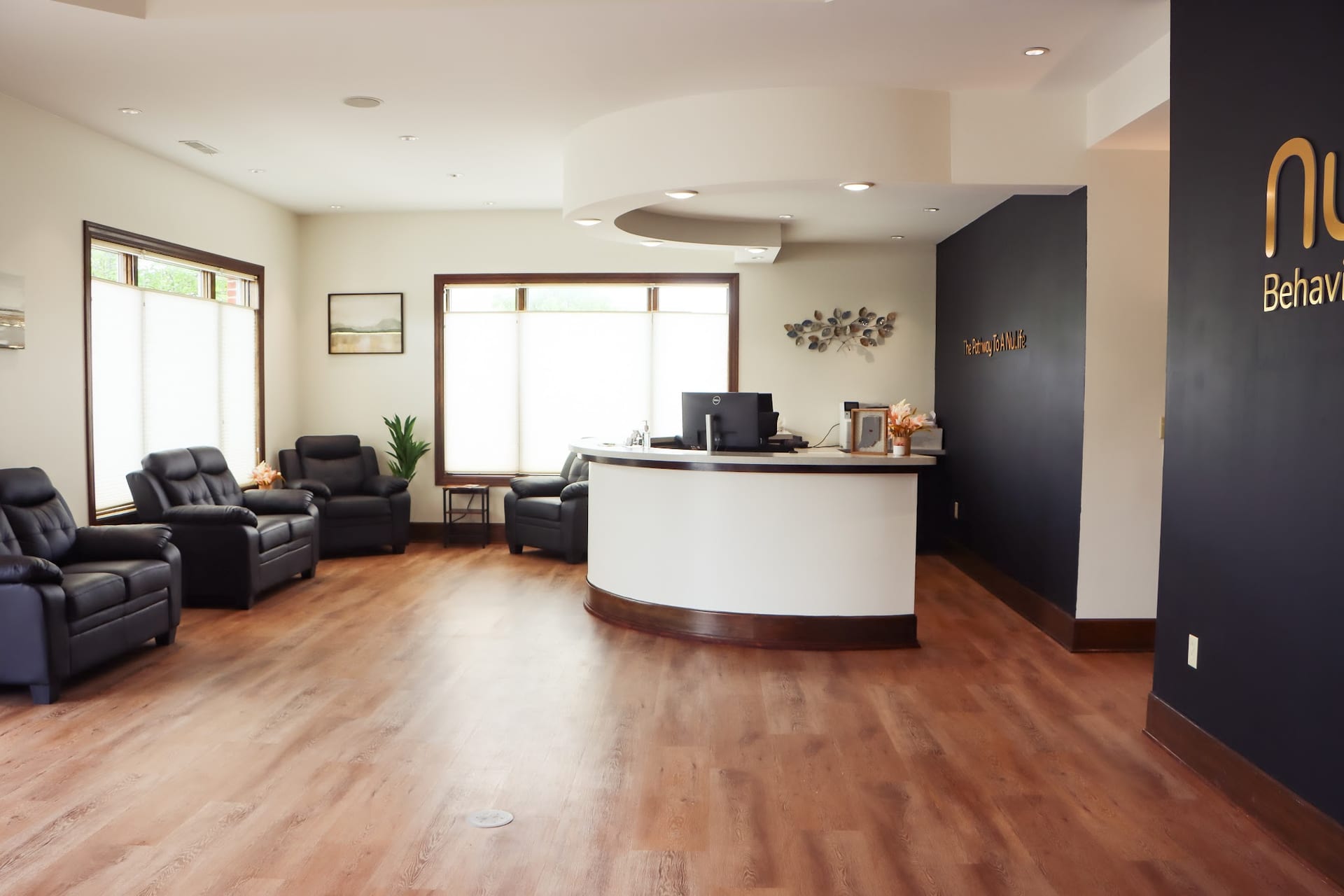 Modern reception desk and black leather seating in a behavioral health waiting room